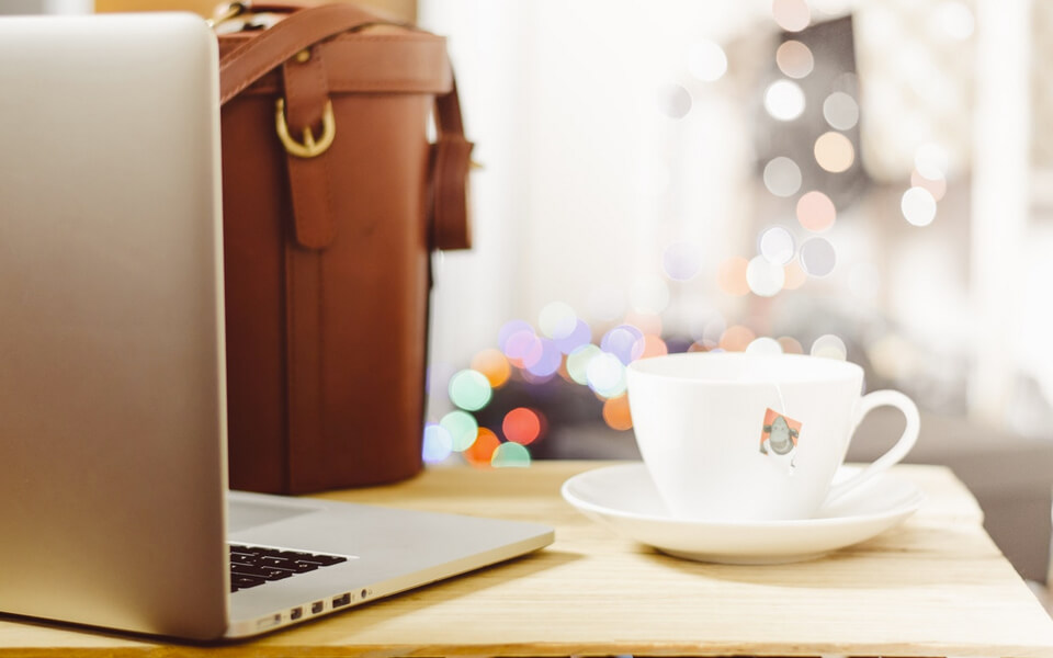 picture containing a laptop, coffe, a bag